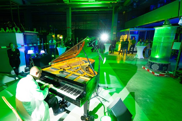 Pianist am Flügel in der grün ausgeleuchteten Wasserbauhalle