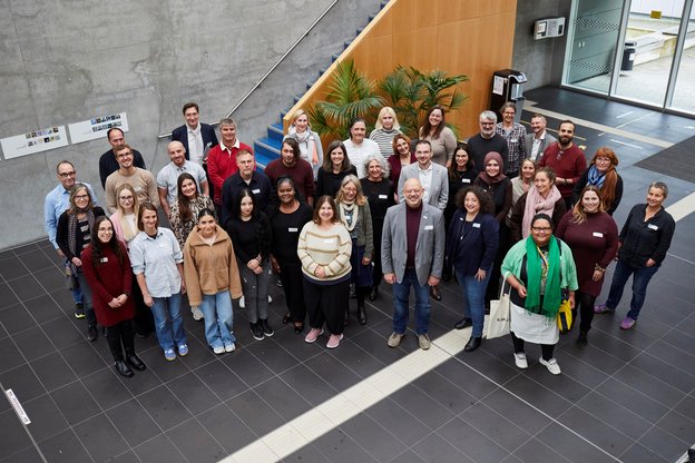 Gruppenfoto der neuen Mitarbeitenden in einem Hörsaalgebäude