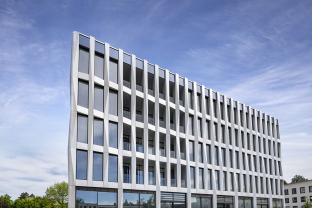 Foto der Fassade des neuen Studierendenhauses vor strahlend blauem Himmel